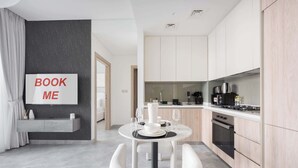 Una cocina moderna con comedor, un letrero que dice 'BOOK ME' y vista al salón.