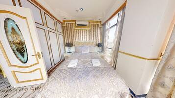 A luxurious bedroom with a large bed, ornate curtains, and a decorative ceiling.
