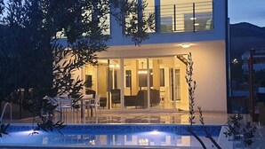 Una casa moderna de dos pisos con puerta de vidrio que da a un comedor.