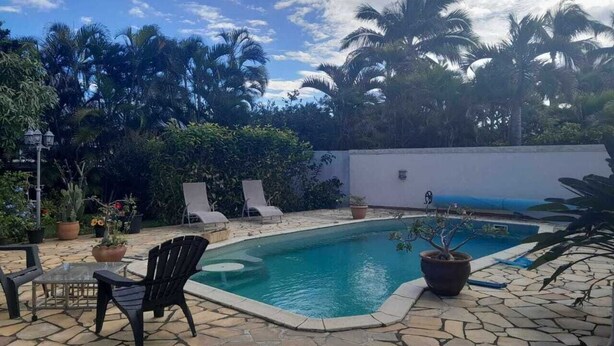 A swimming pool with lounge chairs and potted plants. - Comfortable house in a quiet area close to the sea and amenities in a seaside resort. (L'Étang-Salé les bains)