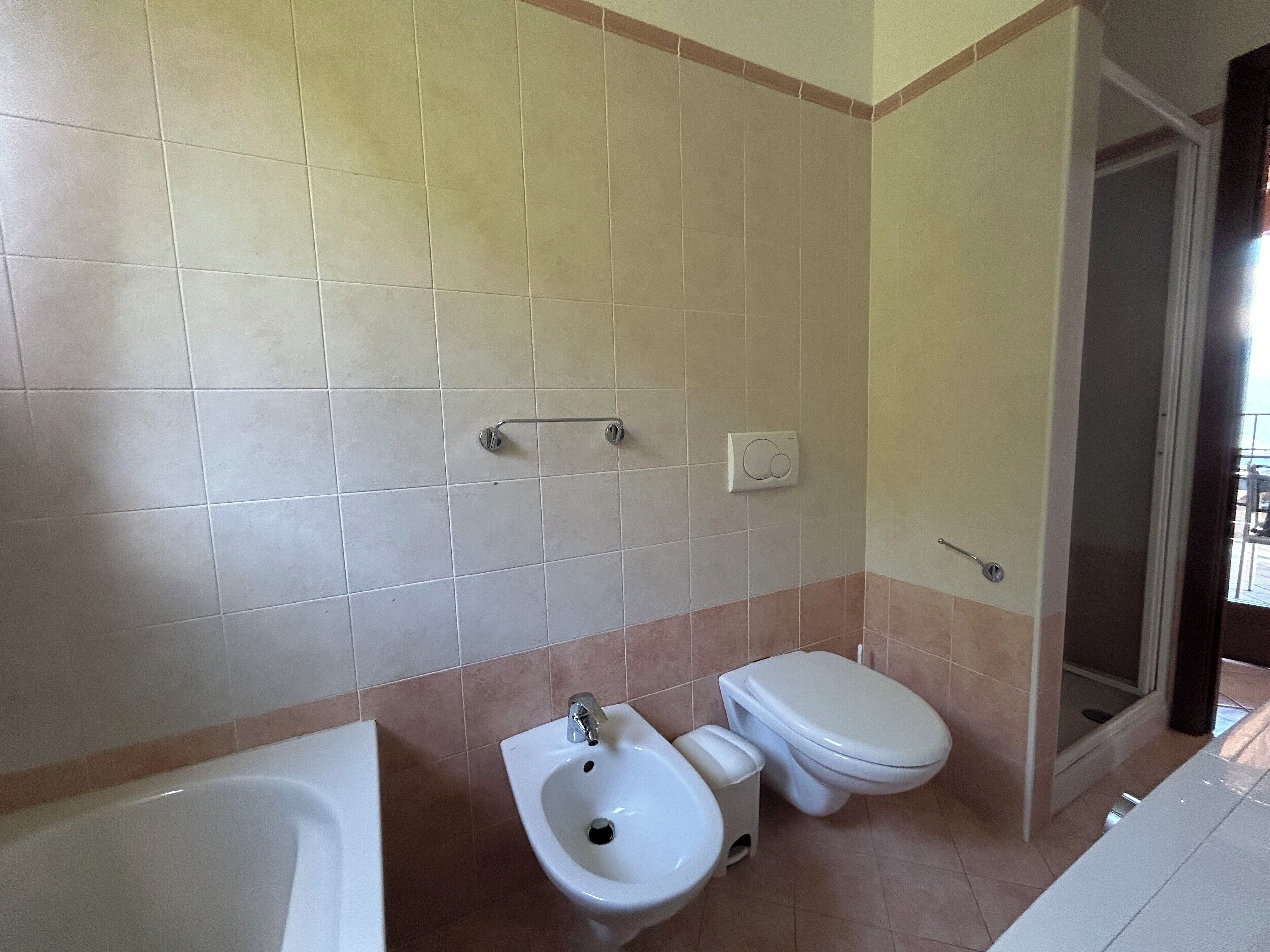 A bathroom with a bathtub, bidet, and toilet.