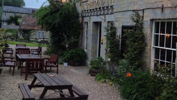 The Greyhound Inn har stenväggar, uteservering och en innergård med grusbeläggning.