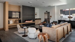 Ein modernes Wohnzimmer mit Kamin, Ledersofa und Flachbildfernseher.