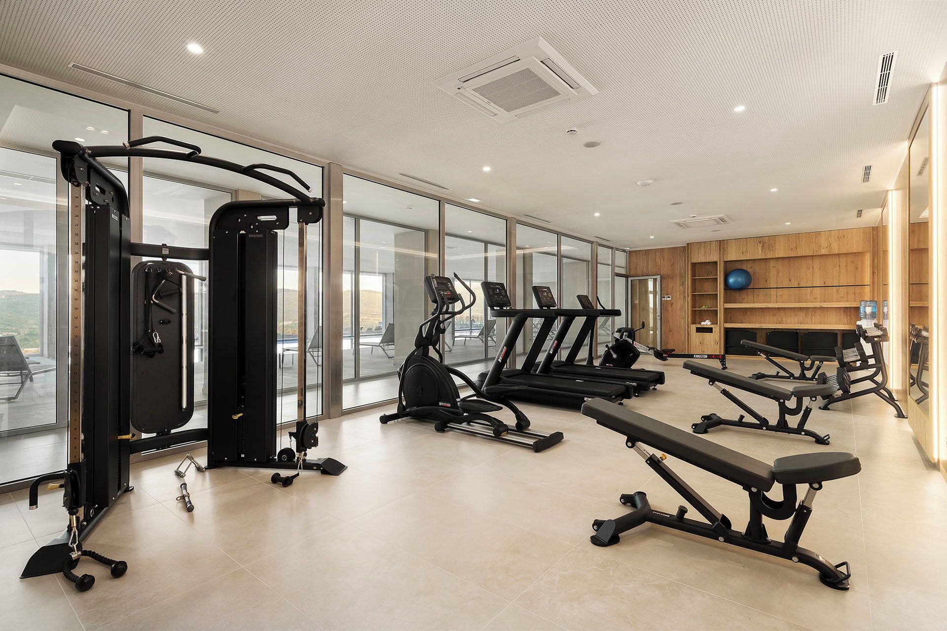 Une salle de sport moderne équipée de machines de cardio, de poids libres et d’un banc de musculation.