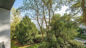 A residential area with trees, a car, and a building in the background. - Intimate Apartment | Two Bedrooms, Work Desk (Wrocław)