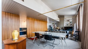 Um interior moderno com uma parede de destaque em madeira, uma mesa de mármore e um design minimalista.