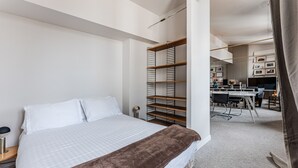 Um quarto bem organizado com cama, escrivaninha e prateleiras.