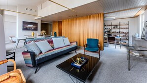 Uma sala de estar moderna com sofá, mesa de centro e poltrona azul.