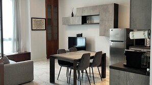 Una cocina moderna con comedor, piso de mármol y electrodomésticos integrados.