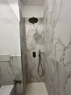 Een douche, een haardroger, handdoeken, toiletpapier