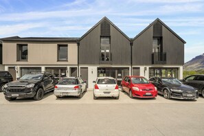 Un edificio moderno dotato di garage e con un cartello 'For Lease'.