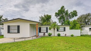 Een modern gelijkvloers huis met plat dak, een voortuin en een verzorgd gazon.