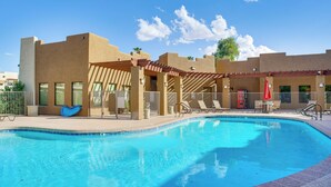 A swimming pool with lounge chairs and umbrellas, surrounded by buildings with a modern architectural style. - Unwind Poolside! Condo 1 Mi to South Mountain Park (Phoenix)