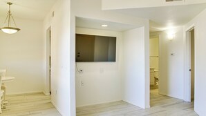 A clean, white-walled room with a wooden floor, a small table, and a hanging light fixture. - Unwind Poolside! Condo 1 Mi to South Mountain Park (Phoenix)