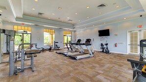 Ein großzügiger Fitnessraum mit Laufbändern, Kraftgeräten und Fahrrädern.