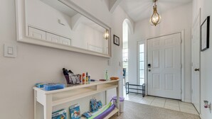 A hallway with a white door, a white console table with storage boxes, and a mirror above it. - 10 Mi to Disney World: Townhome w/ Community Pool! (Kissimmee)