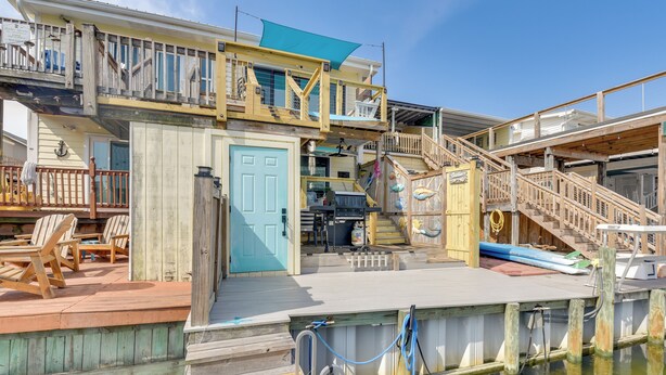 Eine mehrstufige Holzterrasse mit Pool, Sitzgelegenheiten im Freien und einer Garage.