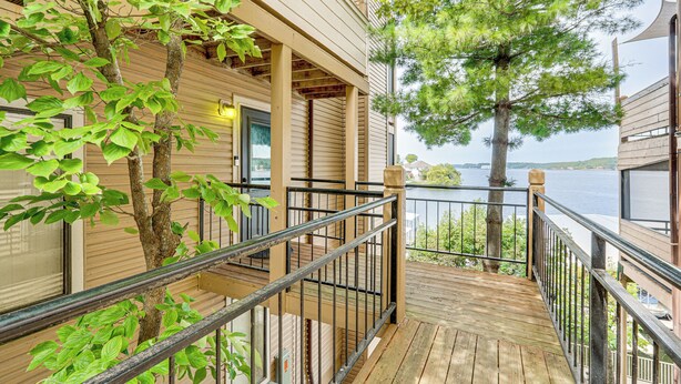 A wooden deck with a metal railing overlooking a body of water.