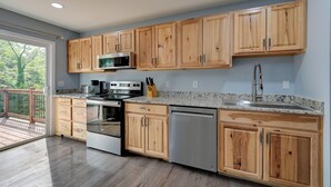 A modern kitchen with wooden cabinets, stainless steel appliances, and a granite countertop. - 12 Mi to Downtown Winston-salem: Apt w/ Balcony! (Winston-Salem)