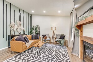 A modern living room with a sofa, chairs, a coffee table, and a fireplace. - Walk to Table Rock Lake: Updated Cabin w/ Deck! (Kimberling City)