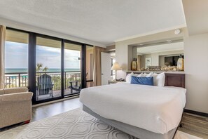 A hotel room with a large bed, a chair, a desk, and a view of the ocean. - Balcony + Resort Perks: Myrtle Beach Escape (Myrtle Beach)