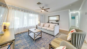 Un salon avec un canapé, une table basse et un ventilateur de plafond.