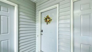 A white front door with a wreath, a doormat, and a gray sidelight. - 3 Mi to IU: Dog-friendly Condo w/ Pool Access! (Bloomington)