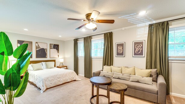 A bedroom with a bed, a sofa, a ceiling fan, and a large plant. - Clinton Retreat Near Norris Lake & Knoxville (Clinton)