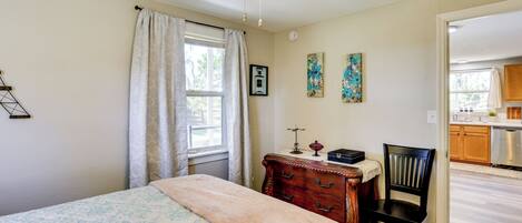 A bedroom with a bed, a dresser, a chair, and a ceiling fan.