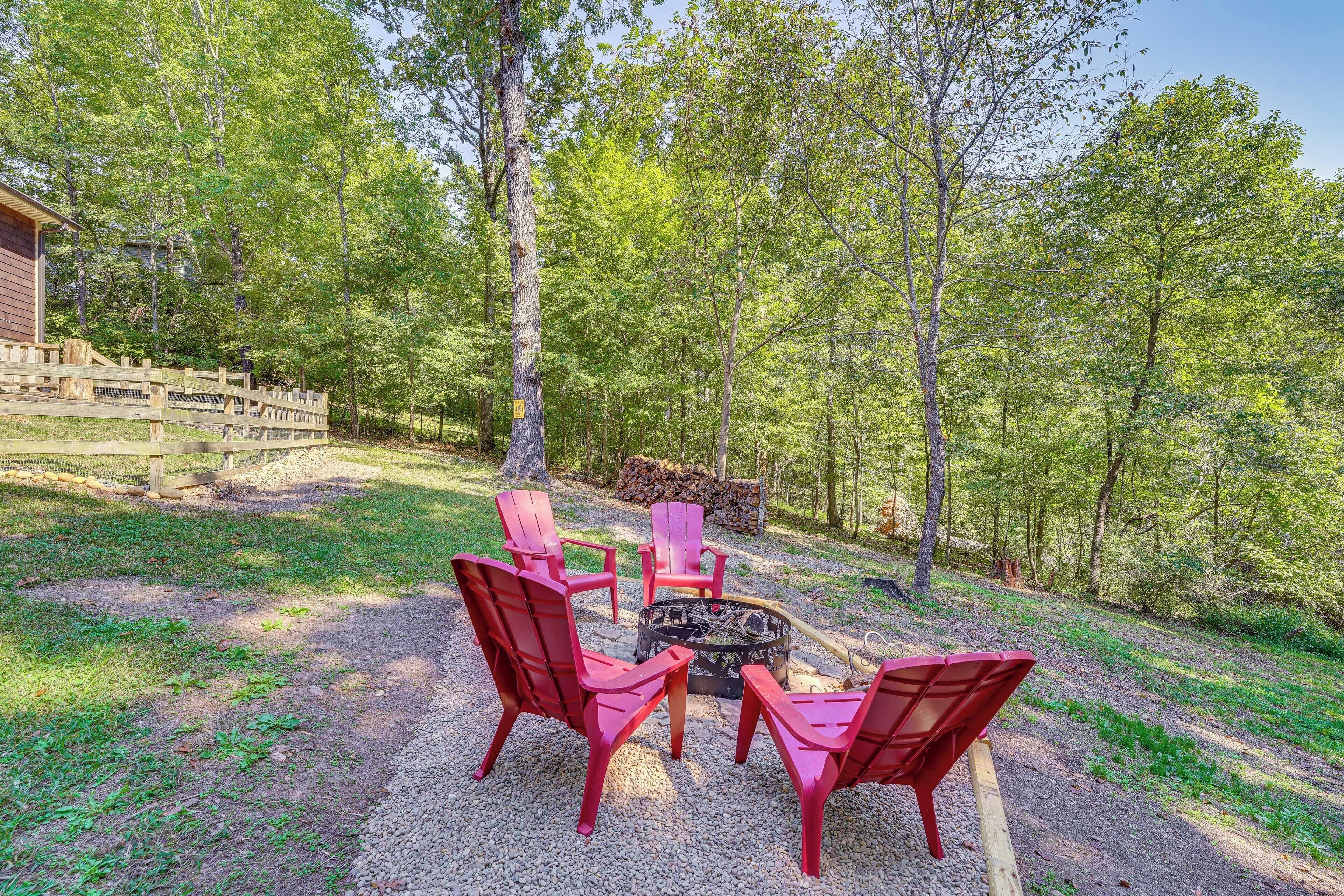 A fire pit area with red Adirondack chairs and a wooden deck.