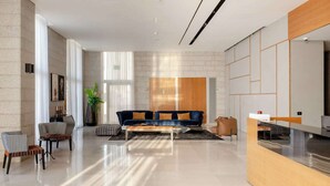 Amplia sala de estar con un sofá moderno, una mesita de centro y un comedor con una mesa y sillas de madera.
