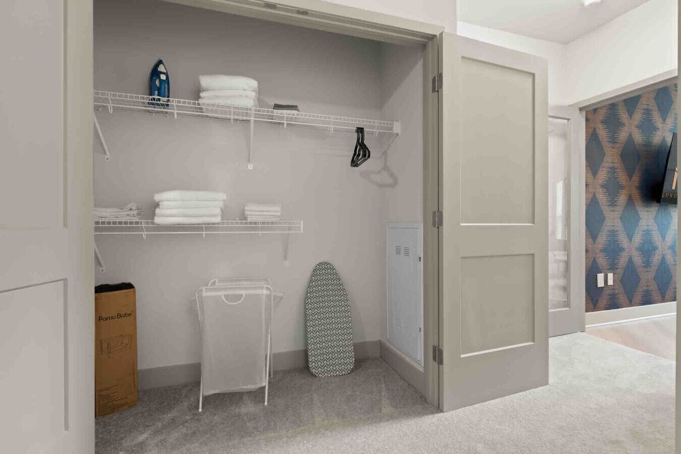 A walk-in closet with shelves, a hanging rack, and a storage bin.