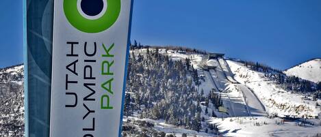 The property stands near Utah Olympic Park, a renowned winter sports venue featuring ski jumps and mountain terrain, visible from the surrounding area.