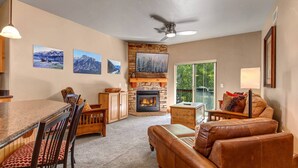Una sala de estar acogedora con chimenea, un comedor con sillas y un sofá.