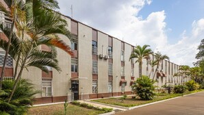 A multi-story building with a tiled facade, air conditioning units, and a gated entrance.