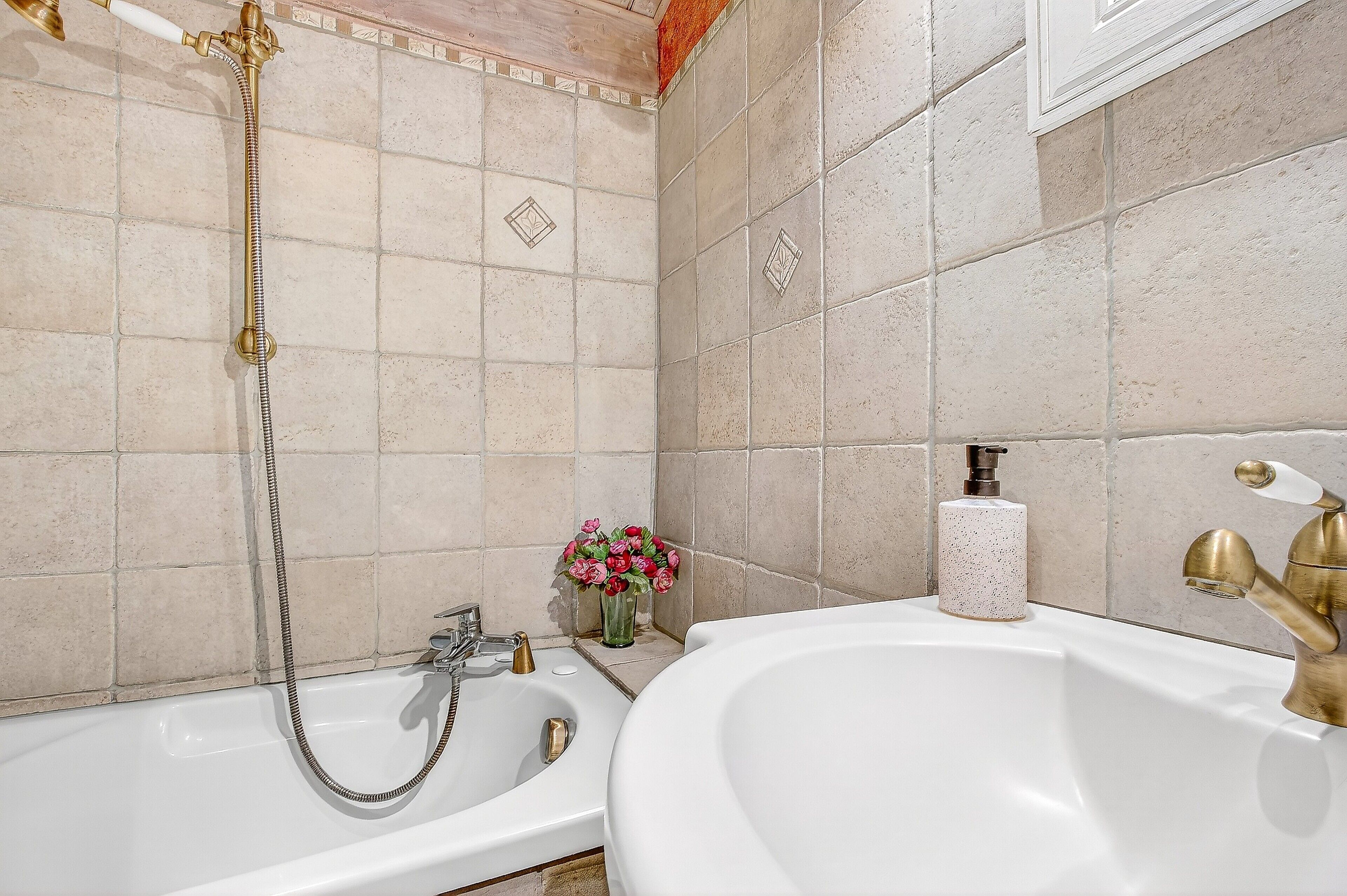 A bathroom with a bathtub, a shower, and a sink.