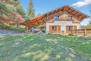 A house with a sloped roof, a covered patio, and a stone exterior.