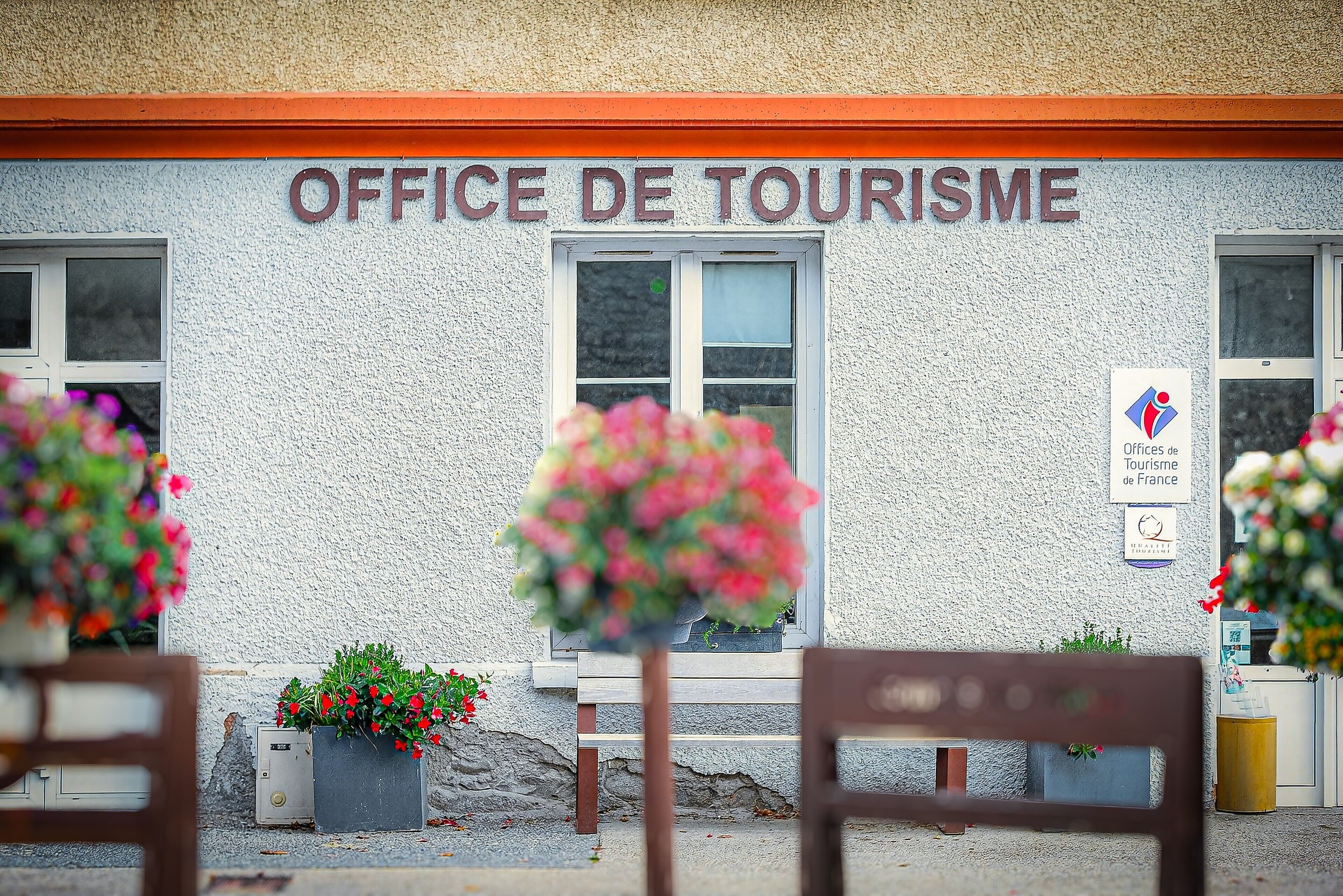 Ein Gebäude mit einem Schild, auf dem 'OFFICE DE TOURISME' steht, und einer Plakette, die angibt, dass es zum Office de Tourisme de France gehört.