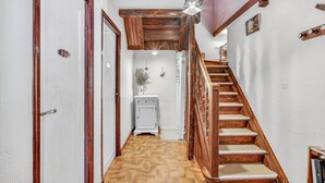 A wooden staircase with a herringbone floor pattern leading to a landing.