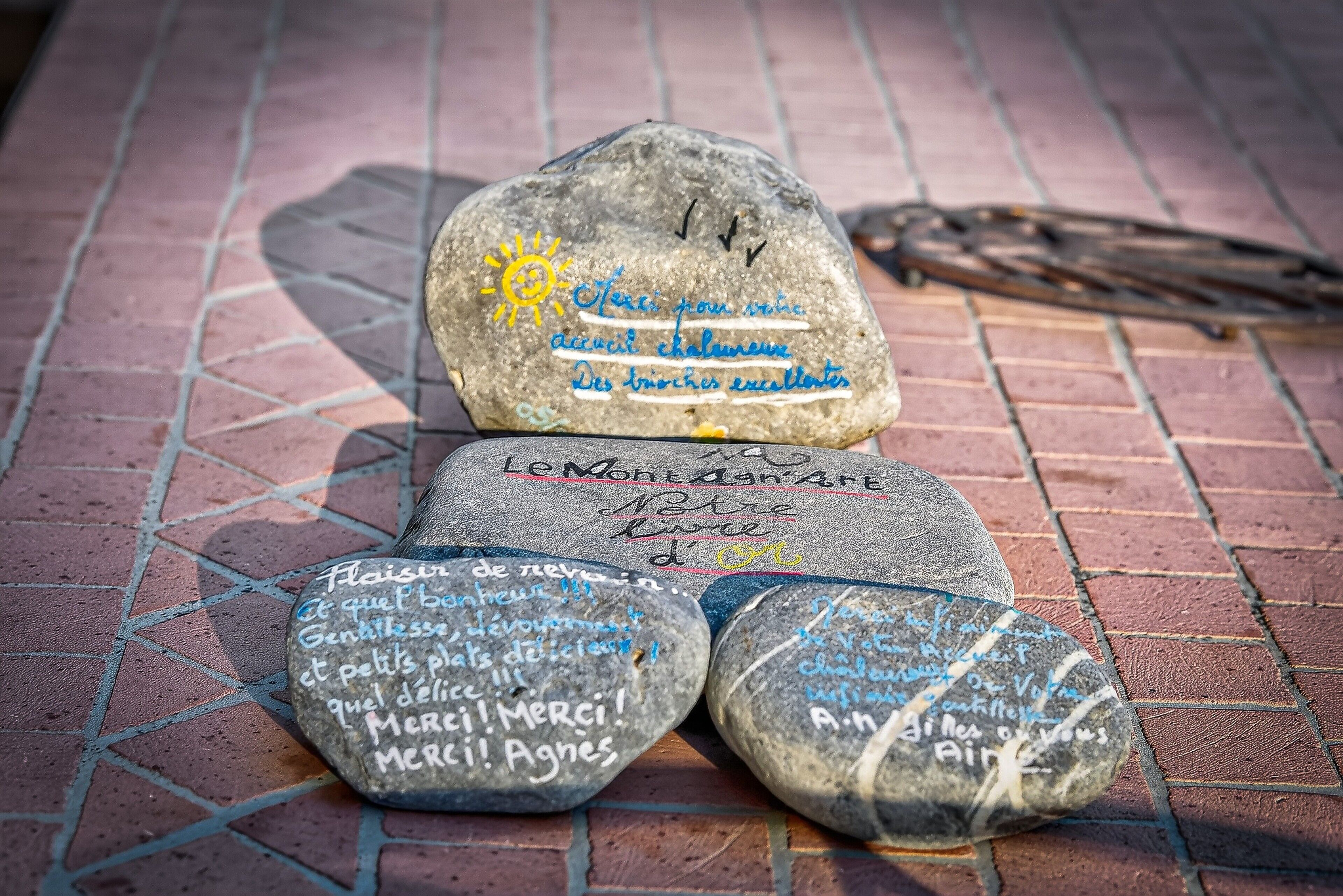Una piedra con inscripciones y un pájaro sobre una superficie de baldosas.