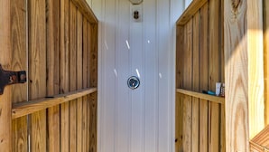 A wooden door with a keyhole, flanked by wooden panels and a small light fixture above it. - A Wave From It All.  Great location-short walk to beach and Kure Beach Pier. (Kure Beach)