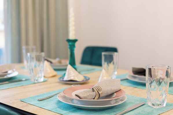 A dining table set with plates, glasses, and a napkin.