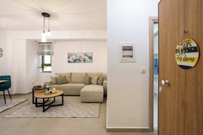 A modern living room with a sofa, coffee table, and a decorative sign on the door.