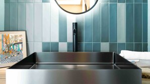 A modern kitchen with a sleek black sink, a wooden countertop, and a tiled backsplash. - La Croce Apartments (Castelnovo ne' Monti)