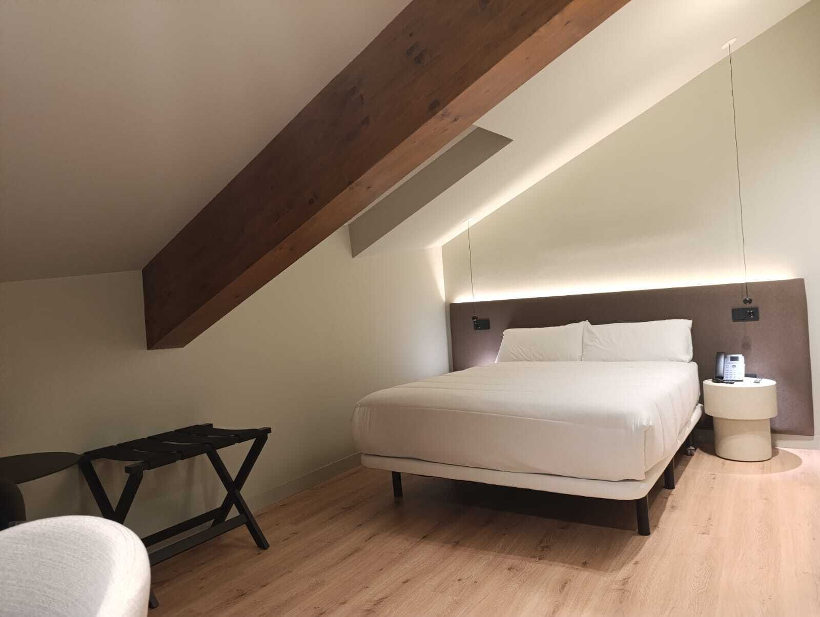 Una moderna camera d'albergo con un letto grande, una scrivania e un comodino.