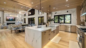 Una cocina moderna con una isla grande, armarios de madera y salpicadero de piedra.