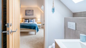 Une chambre à coucher avec un lit, une table de chevet et un luminaire fixé au mur.