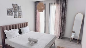 A modern bedroom with a large bed, a mirror, and artwork on the wall. - Charmant Appart Punique au Cœur de Carthage (Carthage)
