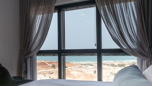 Une chambre d’hôtel avec une grande fenêtre, un lit et des rideaux.