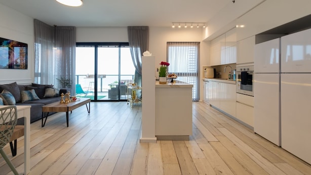 Un appartement moderne comprenant un salon, une cuisine et un balcon.